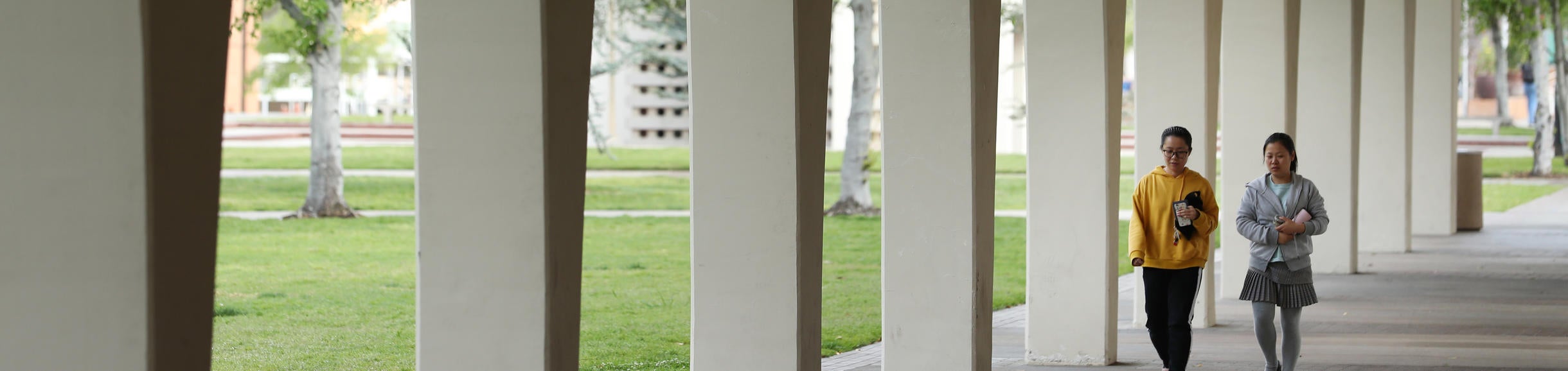 Two people walking down Rivera Library archway